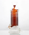 Next Level Glass Cold Brew Coffee Tower Featuring An Adjustable Speed Dripper And Clever Spiral Cooling Tube For Killer Iced Coffee Or Tea Effortlessly with dark brew and ice.