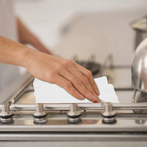 Person using Heavy Duty Kitchen Cleaning Wipes For Microwave Air Fryer Stove And Cooktops All Purpose Appliance Cleaner Cloths on stovetop.