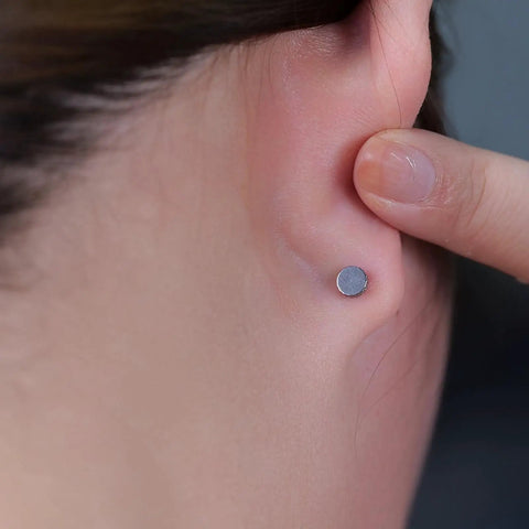 Nailed It 20G Titanium Screw Back Earrings For Sensitive Ears Men Women, close-up view on ear with a smooth silver-tone finish.