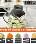 Mandoline slicer with 6 blades and safety guard; clear housing over a glass bowl with cucumber slices.