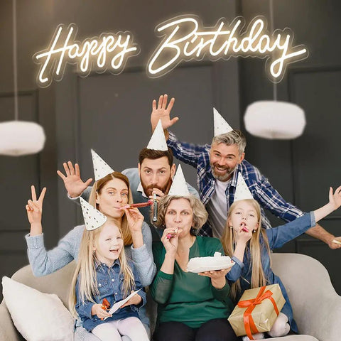 Family party with "Happy Birthday" neon LED sign backdrop, part of the Two Pack Birthday Neon LED Sign Set with Dual Display Options.
