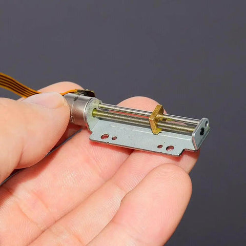 Heavenly Smooth 8MM DC 5V 12V Precision Stepper Motor With 30Mm Stroke Linear Actuator in hand, showcasing metal build and design.