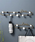 Top Shelf Gold Wrought Iron Letter Wall Hooks for keys coats and hats, featuring a stylish love design with hooks.