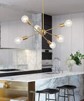 Modern Sputnik Chandelier With 6 Lights In Brushed Brass above kitchen counter with marble finish