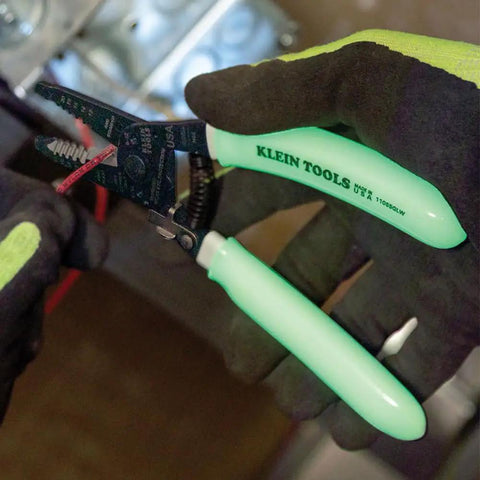 Glow In The Dark Grips Wire Stripper And Cutter With Serrated Curve Nose For 10 To 18 AWG Solid And 12 To 20 AWG Stranded Wire Pro Grade Tool Made In USA in use with glow handles visible.