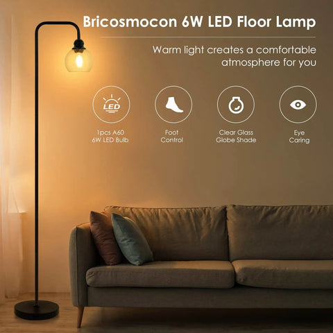 Cool Industrial Glass Globe LED Floor Lamp 63 Inch Tall Black Standing Reading Light next to sofa with warm glow in living room.