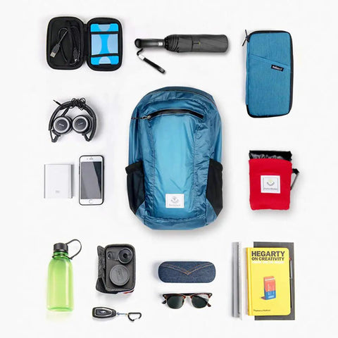 Ultra Lightweight Water Resistant Packable Go To Hiking Daypack For Travel And Outdoor Adventures 16L Blue Backpack That Folds Into A Wallet Sized Pouch surrounded by various items