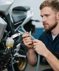 Mechanic using Brake Bleeder Hose Kit For Cars And Motorcycles With One Way Check Valve Tube Bleeding Tool on motorcycle