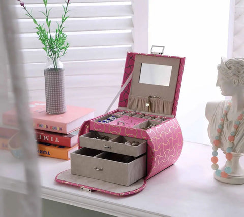 Eight Point Eight Inch Hot Pink Travel Jewelry Organizer Case With Built In Mirror And Snug Pockets on a dresser with jewelry inside.
