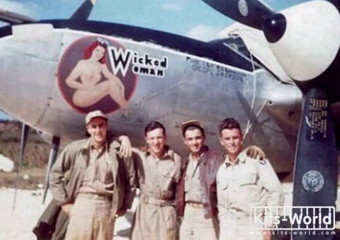 Four men posing in front of a WWII aircraft with "Wicked Woman" nose art. One Seventy Two Scale P 38 Lightning Decal Set For Aircraft Models, Pro Grade Water Slide Decals For Modelers, Easy Apply, High Detail WWII Style Markings, Authentic Accessories For Hobbyists, Durable Paper Decals.