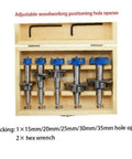 Front view of a 5-piece Forstner drill bit set with blue knobs in a wooden storage box; sizes 15–35 mm.