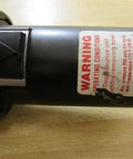 Close-up of hydraulic component with warning label for Valve 9 821 233 101 With One Eighth Inch Top Thread And One Quarter Inch Side Thread.