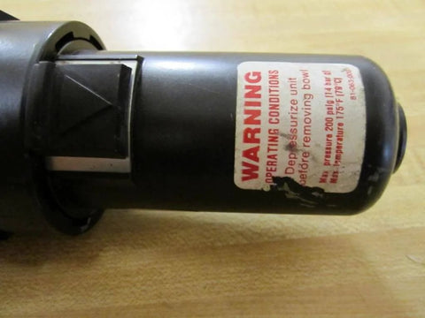 Close-up of hydraulic component with warning label for Valve 9 821 233 101 With One Eighth Inch Top Thread And One Quarter Inch Side Thread.