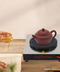 Keep Your Morning Brew Piping Hot With This Rugged Stainless Steel Coffee Warmer Plate Featuring Auto Shut Off And Sturdy Grip Base built for teapots on a wooden table.