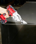 21V Brushless Cordless Sheet Metal Shear With Two Batteries And 360 Degree Pivoting Head cutting through stainless steel sheet.