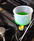 Universal Spill Proof Coolant Fill Funnel Kit With Complete Adapter Set For All Vehicles in use, featuring a transparent funnel and coolant.