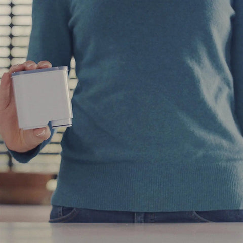 Person holding AquaClean Original Calc and Water Filter for coffee machines, showcasing compact size and design.