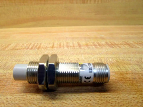 Industrial Automation Inductive Proximity Sensor 5mm Sensing Range Built Tough, 10 to 40V DC, PNP Output, RoHS Compliant, Cylindrical Sensor Body, Model E2E X5MF1 M1 for Factory Automation and Industrial Control on wooden surface