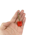 Red pin from Archery Target Pins 15 Pack Durable Plastic And Manganese Steel Pins For Holding Paper Targets On Foam, 6.6 cm length shown in hand