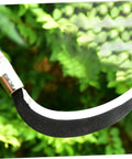 Close-up of a Manganese Steel Weeding Sickle Set Lightweight Garden Tool for Fast Grass Cutting and Weeding blade in foliage background.