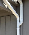 Downspout Gutter Y Connector 2x3 Upright Aluminum High Gloss White Connects Two Downspouts Into One No Fuss Quick Fit Gutter Accessory For Seamless Rain Drainage Upgrade installed on residential exterior wall angle