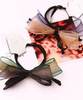 Two hair accessories with bows on white kraft jewelry display cards with hole for retail display and packaging.