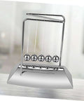 Z Shape Newton Cradle Pendulum Desk Toy For Home Office Decor on modern desk, silver finish, demonstrating energy dynamics.