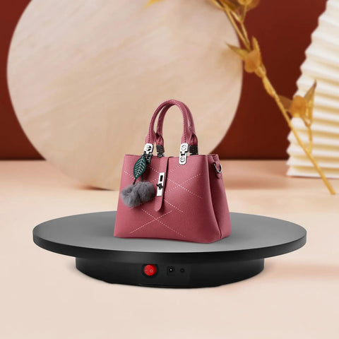 Smooth Electric Rotating Display Stand 360 Degree Turntable with Pure Copper Motor showcasing a pink handbag on a sleek black base.