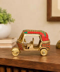 Sick Red Brass Auto Rickshaw Replica With Stone Studded Details Classic Indian Tuk Tuk Model Display Piece on wooden table.
