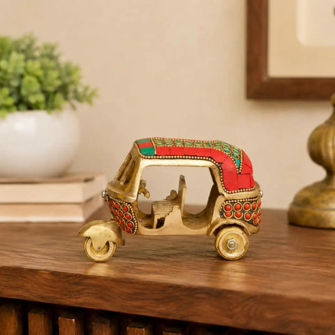 Sick Red Brass Auto Rickshaw Replica With Stone Studded Details Classic Indian Tuk Tuk Model Display Piece on wooden table.