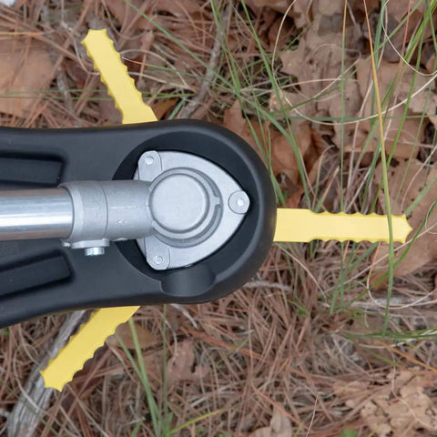 Trimmer head with yellow Push N Load Nylon Replacement Blades for Three Blade Trimmer Heads on grass and leaves