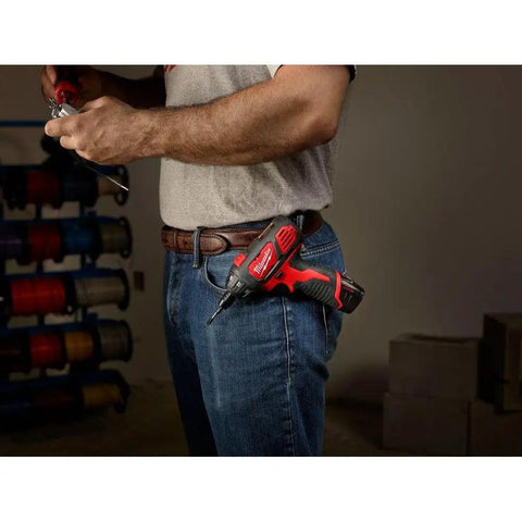 Person holding 12 Volt Cordless Hex Screwdriver Kit with Two 1.5Ah Batteries, Charger, and Tool Bag in a workshop setting.