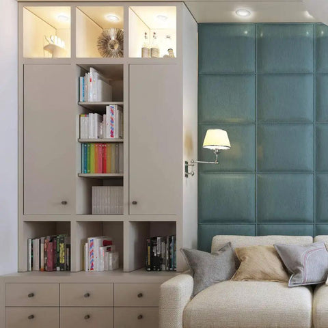 Modern living room with beige storage cabinet, bookshelves, blue accent wall, and a cream sofa with cushions.