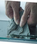 Two Rolls Butyl Repair Tape Sealant For Roof Leaks, Pipe Cracks, And Outdoor Surfaces being applied on glass