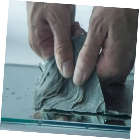 Two Rolls Butyl Repair Tape Sealant For Roof Leaks, Pipe Cracks, And Outdoor Surfaces being applied on glass