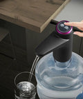Portable Water Dispenser For 2 To 5 Gallon Bottles With USB Charging Pump in use, dispensing water from a large bottle into a glass.