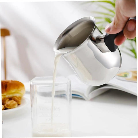 Turkish Coffee Pot 180ml Stainless Steel With Anti Scalding Handle And Lid pouring milk into a glass on a tabletop.