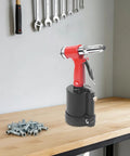 Pro Pneumatic Rivet Gun Kit With Heavy Duty Air Riveter Tool For Automotive Repair Jobs Built From Tough Stainless Steel And Durable Aluminum Alloy For Long Lasting Gutsy Performance On Every Single Job. red pneumatic rivet gun on workbench with rivets