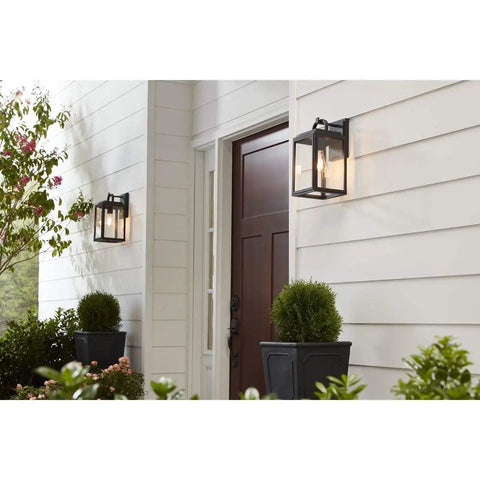 Grandbury Collection 1-Light Clear Glass Farmhouse Outdoor Wall Lantern in Textured Black on porch by wooden door