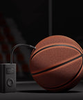 Portable Electric Air Compressor 2 With 150 Psi, inflating a basketball, emphasizing compact design and digital display.
