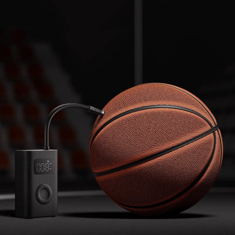 Portable Electric Air Compressor 2 With 150 Psi, inflating a basketball, emphasizing compact design and digital display.