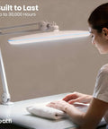 Person using Monster Bright Desk Light With 2200 Lumens Of Crisp 6500K Daylight Glare Free Eye Care 23 Inch Wide Shade Lamp