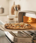Pizza peel, 12-inch aluminum, with handle, used to slide pizza into a compact countertop oven