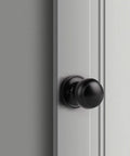 Close-up of a matte black dummy door knob installed on a white door; part of a Two Pack Matte Black Dummy Door Knobs, No Turn Interior Door Handles For Pantry And French Doors, Non Turning Flat Ball Knob, Easy DIY Screw In Install For Right Or Left Handed Doors.