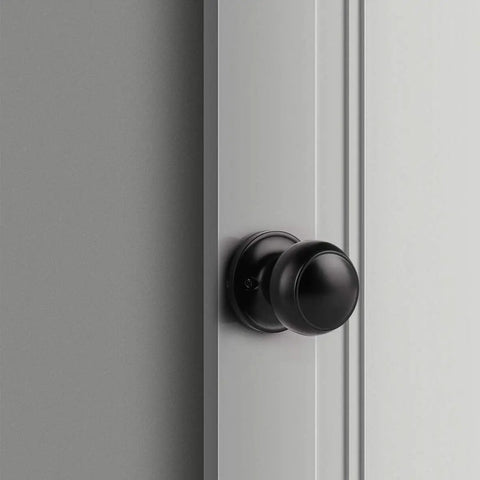 Close-up of a matte black dummy door knob installed on a white door; part of a Two Pack Matte Black Dummy Door Knobs, No Turn Interior Door Handles For Pantry And French Doors, Non Turning Flat Ball Knob, Easy DIY Screw In Install For Right Or Left Handed Doors.