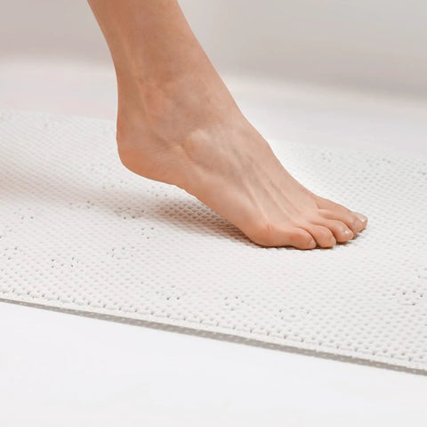 Foot stepping on Cushy Non Slip Tub Mat With Suction Cups For Tubs 17 By 36 Inches White Machine Washable Skid Resistant With Drainage Holes