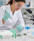 Kickass Sustainable Nitrile Gloves In Vibrant Green, Premium Powder Free And Latex Free Disposable Safety Wear For Restaurant Shifts And Weekend Projects, Hella Grippy 100 Count Large Box worn by a scientist working in a lab.
