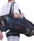 Person carrying XXL Mesh Duffle Bag for Scuba Snorkel Gear and Water Sports Equipment, showing side pocket details.