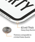 Close-up of Heavy Duty Reflective Aluminum Sign For Private Drives And Home Grounds, showing 63 mil thickness with a quarter for size reference.