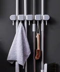 Wall Mounted Broom And Mop Organizer With Four Racks And Five Hooks For Home Kitchen Garage Garden Laundry Room And Bathroom Storage Keeps Cleaning Tools Neatly Stored And Easily Accessible showing tools on hooks and racks.